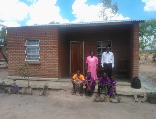 Teachers and students in front of a teacher’s home